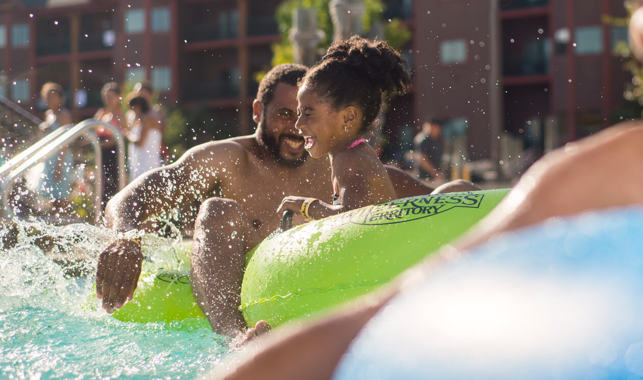 Father and daughter on a tube in the pool
