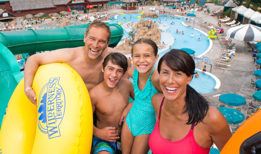 Family of four posing before going down a waterslide