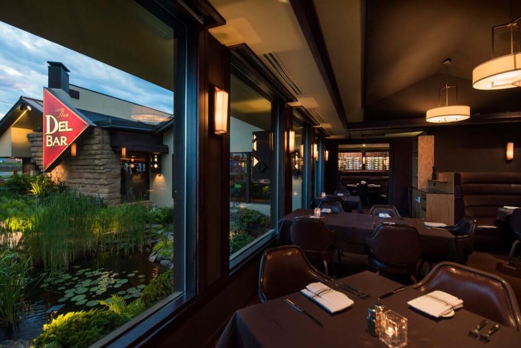 Dell Bar dining area with view of restaurant logo and pond through window