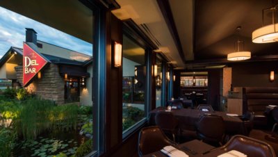 Dell Bar dining area with view of restaurant logo and pond through window