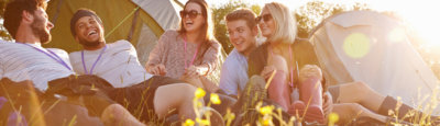 Group of young adults laughing while camping